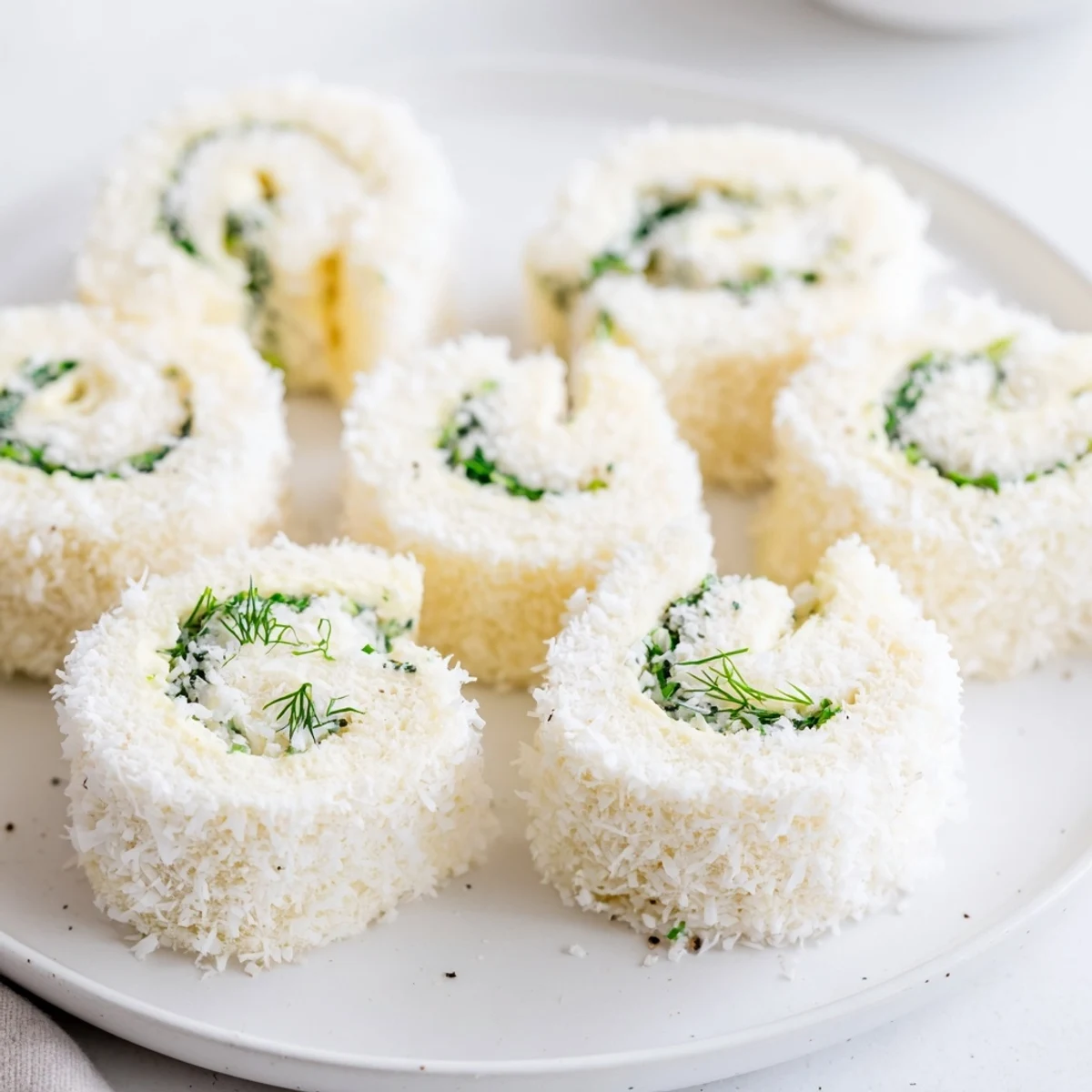 Creamy filling and coconut coating define these whimsical Snowball Tea Sandwich Bites, perfect finger food.