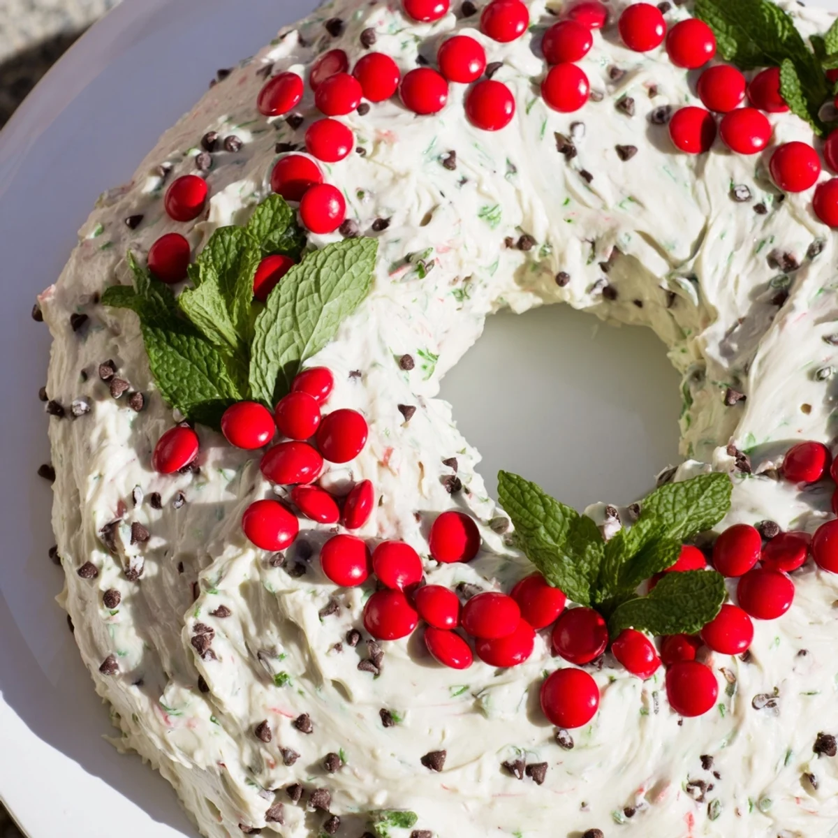 Festive Mint Chocolate Chip Dip Wreath boasts a vibrant green hue, studded with chocolate chips and red candies.
