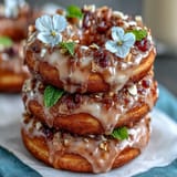 A whimsical Baby in Bloom Mini Donut Tower adorned with edible flowers and pastel sprinkles for a festive baby shower.