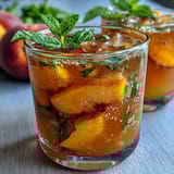 Vibrant Mango Peach Sparkling Tea with juicy fruit puree and chilled black tea, perfect for summer refreshment.