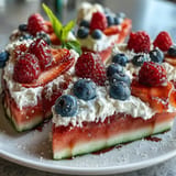 Festive 4th of July Watermelon Pizza with bright berries and fluffy cream.