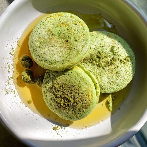 Fluffy Egg White Gingerbread Matcha Soufflé Pancakes, golden brown and drizzled with maple syrup and berries.