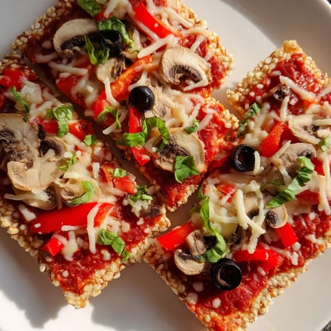 Crispy rice cake pizza squares, baked with melted cheese, fresh veggies, and savory pizza sauce.