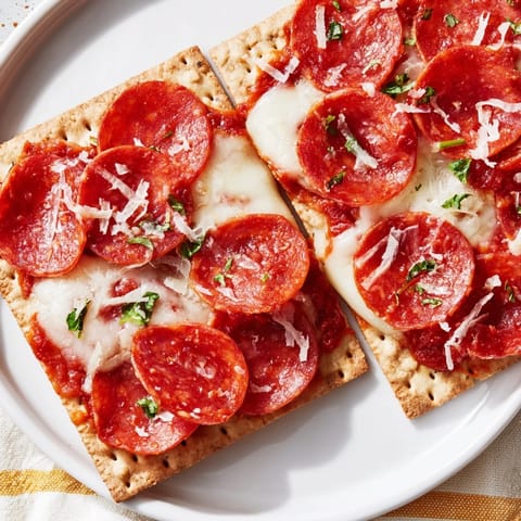 Crispy crackers topped with pepperoni and cheese, fresh from the broiler for easy Pepperoni Bites.