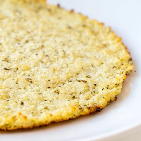 A crispy, oven-baked cauliflower pizza crust, still warm, perfect for your favorite pizza toppings.