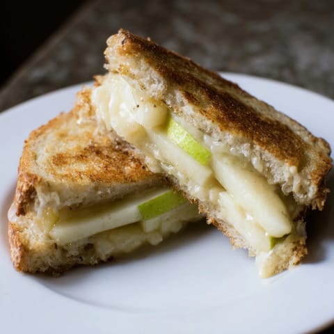 Crisp apple and creamy Brie layers in a delicious grilled cheese, ready to eat.