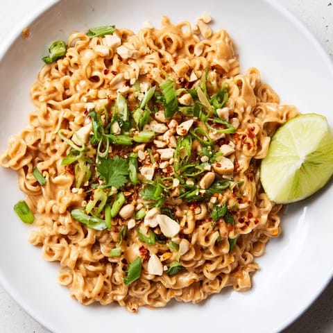 Vibrant spoon of Instant Peanut Thai Sauce Noodles ready, showcasing a rich, nutty, and spicy sauce.