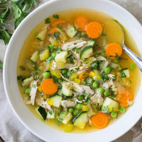 Fresh parsley garnishes this Spring Garden Chicken Soup, served hot alongside crusty bread for dipping.  