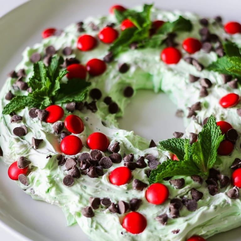 A beautiful holiday photo of a chilling Mint Chocolate Chip Dip Wreath with cookies and pretzel sticks ready to serve.