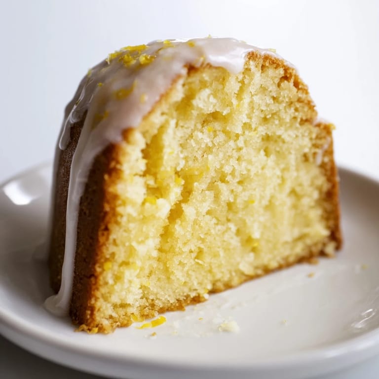 A golden slice of Lemon Yogurt Cake, showing a moist interior with a bright lemon aroma.