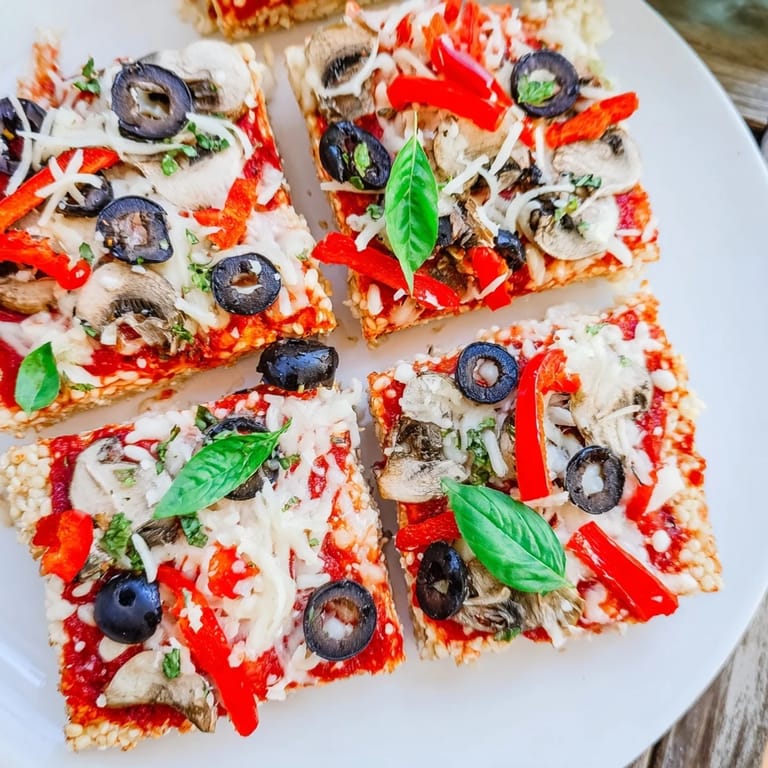 Hot, cheesy rice cake pizza squares topped with colorful peppers, olives, and fresh herbs.
