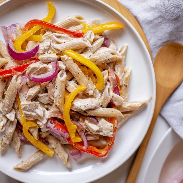 Fajita Chicken Pasta Skillet in a skillet, garnished with cilantro and fresh lime wedges.