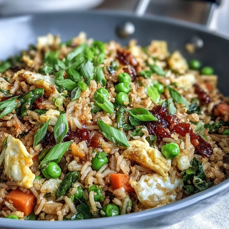 Aromatic fried rice bursting with fresh spring peas, carrots, and ginger, garnished with green onions and sesame oil.