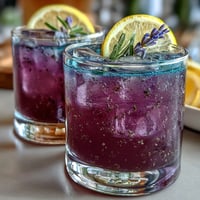 A refreshing purple lemonade with lavender, citrus, and a vibrant hue, perfect for summer sipping.