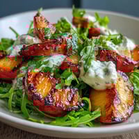 Grilled Peach and Burrata Salad with Honey: caramelized peaches paired with creamy burrata, fresh greens, and a drizzle of golden honey.  